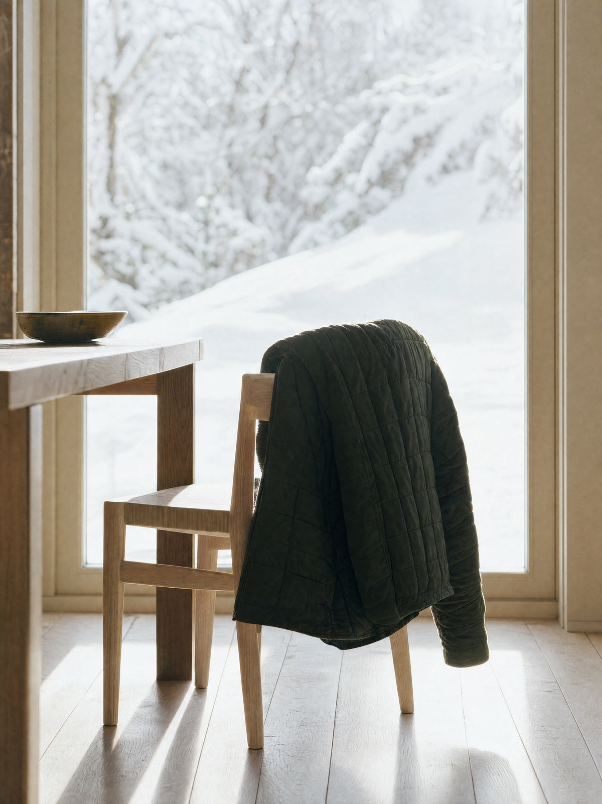 A heavy coat hanging on a single hook by a door